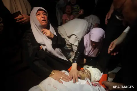 Palestinian women mourn over the body of Abderahman Abu Jalaleh, 25, during his funeral in Beit Lahia, in the northern Gaza Strip, on October 22, 2012. An Israeli air strikes killed two Gaza militants as they clashed wit...