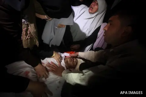 Palestinian women mourn over the body of Abderahman Abu Jalaleh, 25, during his funeral in Beit Lahia, in the northern Gaza Strip, on October 22, 2012. An Israeli air strikes killed two Gaza militants as they clashed wit...