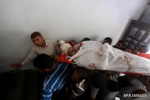 Palestinians carry the body of militant Abed Rahman Abu Jalalah during his funeral in Beit Lahia, in the northern Gaza Strip, on October 22, 2012. An Israeli air strikes killed two Gaza militants as they clashed with tro...
