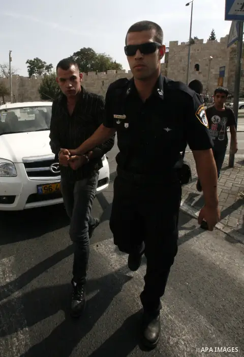 An Israeli police officer detains a Palestinian man at the main market of Jerusalem's old city ahead of Muslim festival of Eid al-Adha on October 22, 2012. Photo by Mahfouz Abu Turk