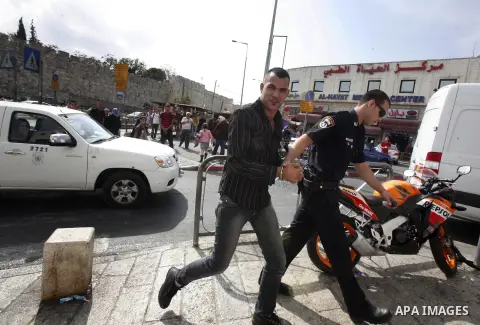 An Israeli police officer detains a Palestinian man at the main market of Jerusalem's old city ahead of Muslim festival of Eid al-Adha on October 22, 2012. Photo by Mahfouz Abu Turk