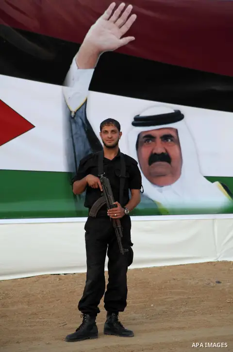A Palestinian security officer stands near a poster of Qatar's Emir Sheikh Hamad bin Khalifa al-Thani in Gaza city on October 22, 2012. The Qatari emir will visit Gaza on October 23 in the first such visit by an Arab lea...