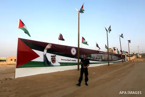 A Palestinian security officer walks near a poster of Qatar's Emir Sheikh Hamad bin Khalifa al-Thani in Gaza city on October 22, 2012. The Qatari emir will visit Gaza on October 23 in the first such visit by an Arab lead...