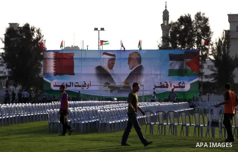 Palestinians attach posters of Hamas prime minister Ismail Haniya and Qatar's Emir Sheikh Hamad bin Khalifa al-Thani in Gaza city on October 22, 2012. The Qatari emir will visit Gaza on October 23 in the first such visit...