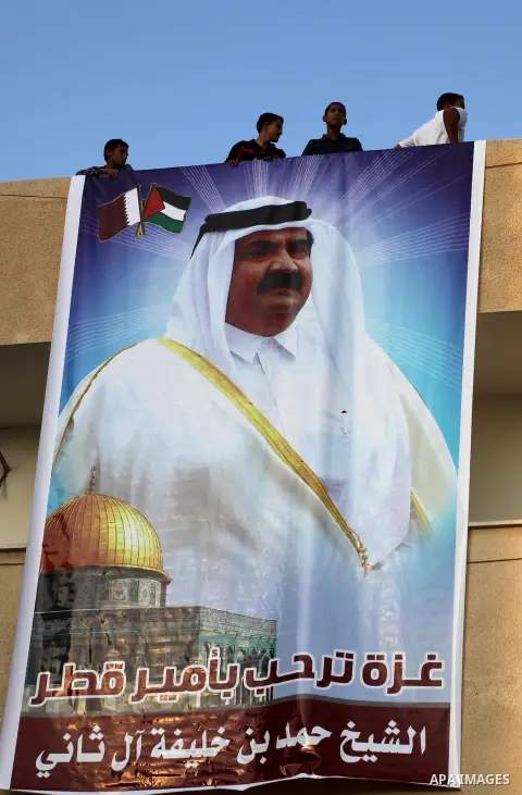 Palestinians attach poster of Qatar's Emir Sheikh Hamad bin Khalifa al-Thani in Gaza city on October 22, 2012. The Qatari emir will visit Gaza on October 23 in the first such visit by an Arab leader since Hamas took over...