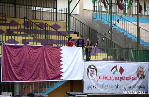 Palestinians attach the Qatari and Palestinian (red, black, white, green) flags in Gaza city on October 22, 2012. The Qatari emir will visit Gaza on October 23 in the first such visit by an Arab leader since Hamas took o...