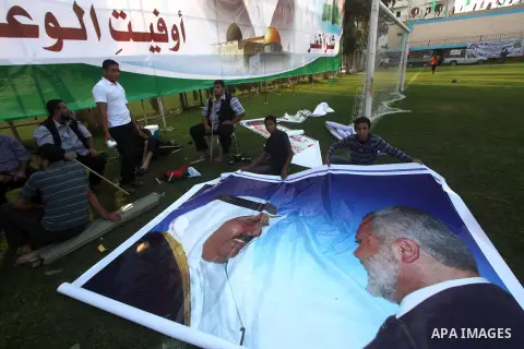 Palestinians attach posters of Hamas prime minister Ismail Haniya and Qatar's Emir Sheikh Hamad bin Khalifa al-Thani in Gaza city on October 22, 2012. The Qatari emir will visit Gaza on October 23 in the first such visit...