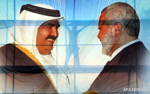 Palestinians attach posters of Hamas prime minister Ismail Haniya and Qatar's Emir Sheikh Hamad bin Khalifa al-Thani in Gaza city on October 22, 2012. The Qatari emir will visit Gaza on October 23 in the first such visit...