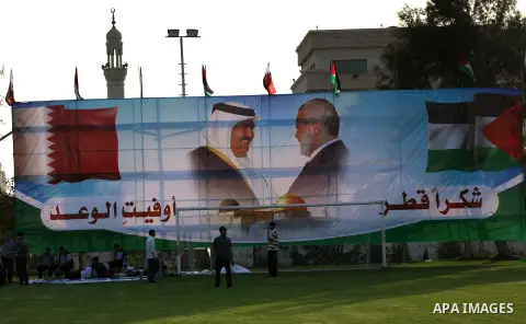 Palestinians attach posters of Hamas prime minister Ismail Haniya and Qatar's Emir Sheikh Hamad bin Khalifa al-Thani in Gaza city on October 22, 2012. The Qatari emir will visit Gaza on October 23 in the first such visit...