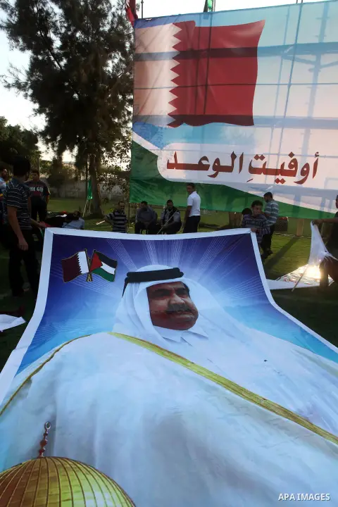 Palestinians attach poster of Qatar's Emir Sheikh Hamad bin Khalifa al-Thani in Gaza city on October 22, 2012. The Qatari emir will visit Gaza on October 23 in the first such visit by an Arab leader since Hamas took over...