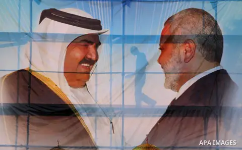 Palestinians attach posters of Hamas prime minister Ismail Haniya and Qatar's Emir Sheikh Hamad bin Khalifa al-Thani in Gaza city on October 22, 2012. The Qatari emir will visit Gaza on October 23 in the first such visit...