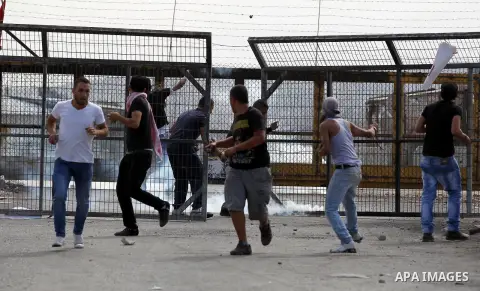 Palestinian protesters throw stones towards Israeli security forces outside Israel's Ofer military prison, near the West Bank city of Ramallah, on October 22, 2012, following a demonstration in support of Palestinian pri...