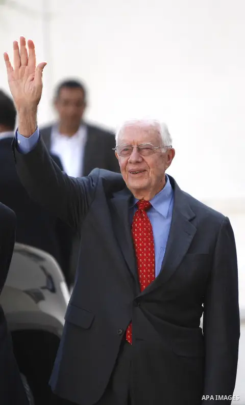 Former US President Jimmy Carter waves as he arrives to the West Bank town of Ramallah, 22 October 2012, where he along with other member of the group of 'Elders' was meeting with the Palestinian Authority President Mahm...