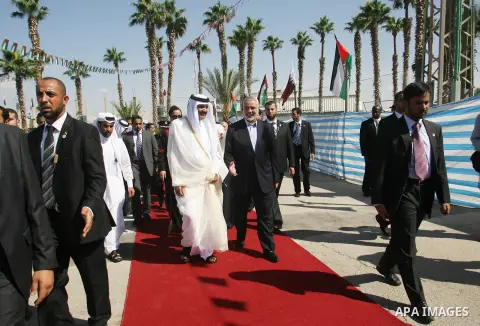 Palestinian Prime Minister in Gaza strip, Ismail Haniyeh walks with the Emir of Qatar Sheik Hamad bin Khalifa al-Thani during a welcoming ceremony at the Rafah border crossing with Egypt in the southern Gaza Strip Octobe...