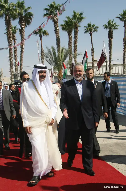 Palestinian Prime Minister in Gaza strip, Ismail Haniyeh walks with the Emir of Qatar Sheik Hamad bin Khalifa al-Thani during a welcoming ceremony at the Rafah border crossing with Egypt in the southern Gaza Strip Octobe...