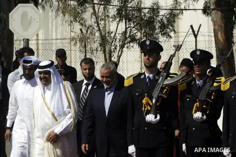 Palestinian Prime Minister in Gaza strip, Ismail Haniyeh walks with the Emir of Qatar Sheik Hamad bin Khalifa al-Thani during a welcoming ceremony at the Rafah border crossing with Egypt in the southern Gaza Strip Octobe...