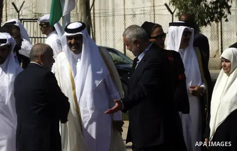 Palestinian Prime Minister in Gaza strip, Ismail Haniyeh walks with the Emir of Qatar Sheik Hamad bin Khalifa al-Thani during a welcoming ceremony at the Rafah border crossing with Egypt in the southern Gaza Strip Octobe...