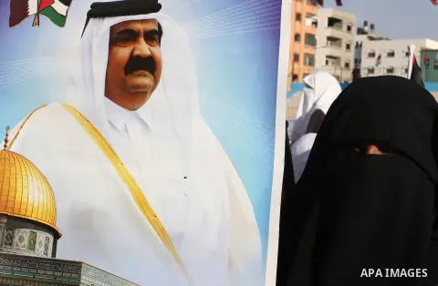 Palestinians stand near posters of the Emir of Qatar Sheikh Hamad bin Khalifa al-Thani in the Gaza city on October 23, 2012. The Emir of Qatar entered the Gaza Strip on Tuesday for a visit that broke the isolation of it...