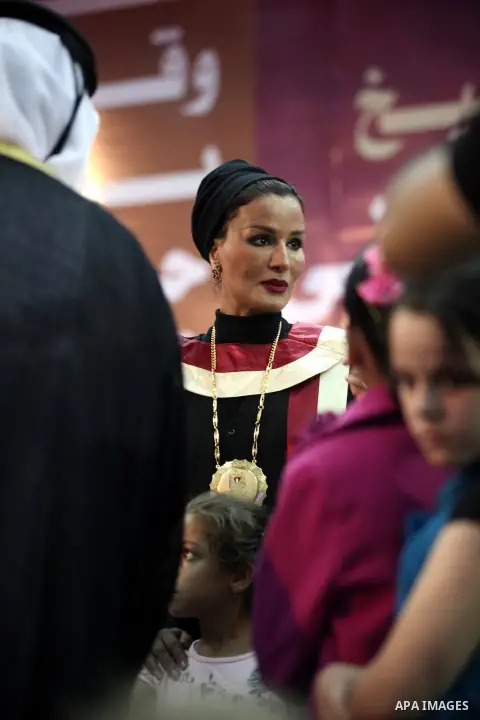 Qatar's First Lady Sheikha Mozah bint Nasser al-Missned stands with the wife of Gaza's prime minister Ismail Haniyah surrounding with Palestinian children at the Islamic University in Gaza city on October 23, 2012. The E...