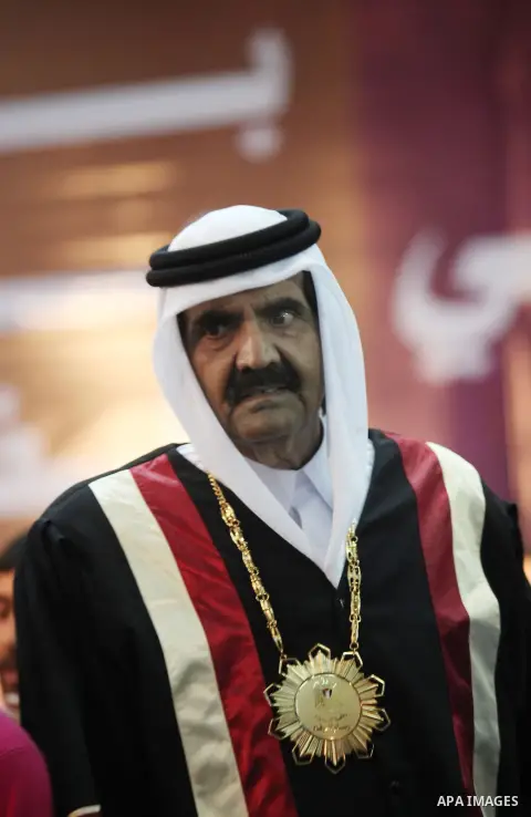 Qatari Emir Sheikh Hamad bin Khalifa al-Thani stands during a celebration surrounding by children at the Islamic University in Gaza city on October 23, 2012. The Emir of Qatar entered the Gaza Strip on Tuesday for a visi...