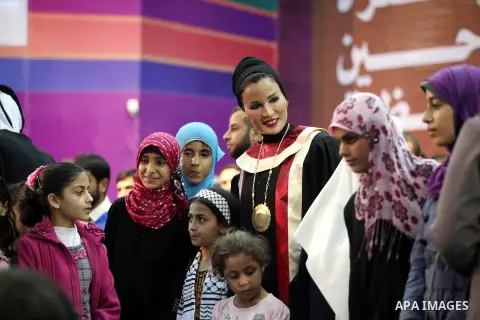 Qatar's First Lady Sheikha Mozah bint Nasser al-Missned stands with the wife of Gaza's prime minister Ismail Haniyah surrounding with Palestinian children at the Islamic University in Gaza city on October 23, 2012. The E...