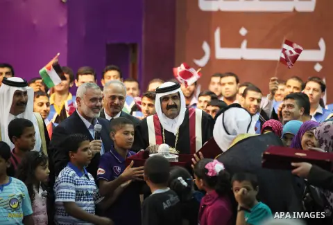 Qatari Emir Sheikh Hamad bin Khalifa al-Thani stand with Palestinian prime minister in Gaza strip, Ismail Haniyah surrounding by children at the Islamic University in Gaza city on October 23, 2012. The Emir of Qatar ente...
