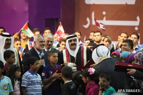 Qatari Emir Sheikh Hamad bin Khalifa al-Thani stand with Palestinian prime minister in Gaza strip, Ismail Haniyah surrounding by children at the Islamic University in Gaza city on October 23, 2012. The Emir of Qatar ente...