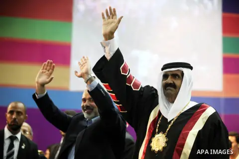 Qatari Emir Sheikh Hamad bin Khalifa al-Thani and Palestinian prime minister in Gaza strip, Ismail Haniyah wave to the crowds at the Islamic University in Gaza city on October 23, 2012. The Emir of Qatar entered the Gaza...