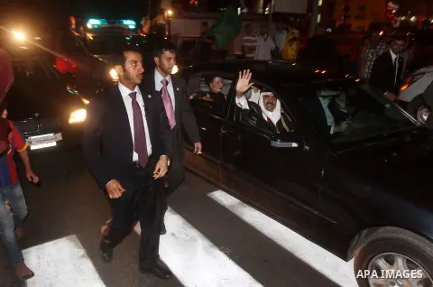 Qatari Emir Sheikh Hamad bin Khalifa al-Thani and his wife Sheikha Mozah bint Nasser al-Missned wave to the crowds as Gaza's Hamas prime minister Ismail Haniya drives in a car in Gaza City on October 23, 2012. The Emir o...