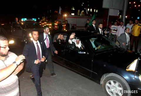Qatari Emir Sheikh Hamad bin Khalifa al-Thani and his wife Sheikha Mozah bint Nasser al-Missned wave to the crowds as Gaza's Hamas prime minister Ismail Haniya drives in a car in Gaza City on October 23, 2012. The Emir o...