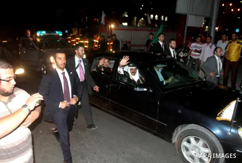 Qatari Emir Sheikh Hamad bin Khalifa al-Thani and his wife Sheikha Mozah bint Nasser al-Missned wave to the crowds as Gaza's Hamas prime minister Ismail Haniya drives in a car in Gaza City on October 23, 2012. The Emir o...