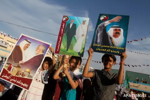 Palestinian Hamas supporters hold posters of the Emir of Qatar Sheikh Hamad bin Khalifa al-Thani, not pictured, as they wait for him to give a speech at the Palestine stadium in Gaza City, Tuesday, Oct. 23, 2012. The emi...