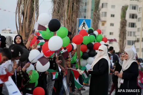 Palestinians hold balloons in the colour of the national flag waits for the arrival of Emir of Qatar Sheik Hamad bin Khalifa al-Thani in Gaza City on October 23, 2012. Qatar's emir was warmly welcomed on a landmark tour...