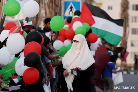 Palestinians hold balloons in the colour of the national flag waits for the arrival of Emir of Qatar Sheik Hamad bin Khalifa al-Thani in Gaza City on October 23, 2012. Qatar's emir was warmly welcomed on a landmark tour...