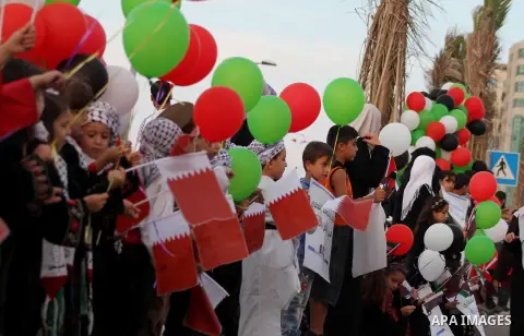 Palestinians hold balloons in the colour of the national flag waits for the arrival of Emir of Qatar Sheik Hamad bin Khalifa al-Thani in Gaza City on October 23, 2012. Qatar's emir was warmly welcomed on a landmark tour...