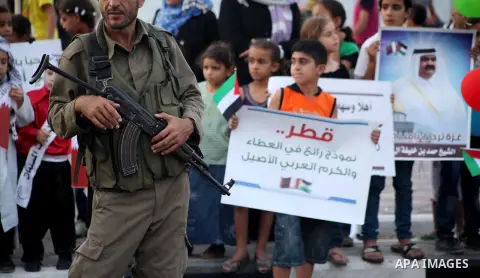 Palestinian children hold posters of the Emir of Qatar Sheikh Hamad bin Khalifa al-Thani, not pictured, as they wait for him to give a speech at the Palestine stadium in Gaza City, Tuesday, Oct. 23, 2012. The emir of Qat...