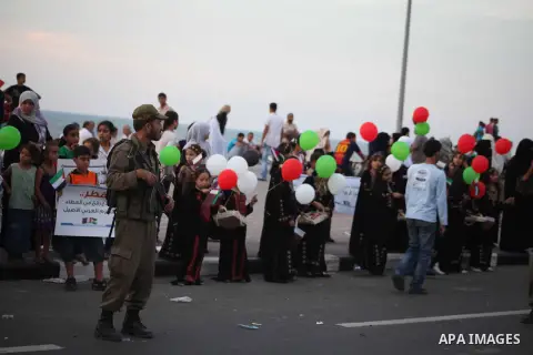 Palestinian women hold balloons in the colour of the national flag waits for the arrival of Emir of Qatar Sheik Hamad bin Khalifa al-Thani in Gaza City on October 23, 2012. Qatar's emir was warmly welcomed on a landmark...