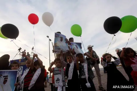 Palestinians hold balloons in the colour of the national flag waits for the arrival of Emir of Qatar Sheik Hamad bin Khalifa al-Thani in Gaza City on October 23, 2012. Qatar's emir was warmly welcomed on a landmark tour...