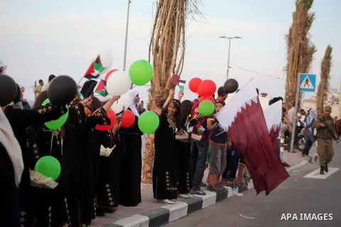 Palestinians hold balloons in the colour of the national flag waits for the arrival of Emir of Qatar Sheik Hamad bin Khalifa al-Thani in Gaza City on October 23, 2012. Qatar's emir was warmly welcomed on a landmark tour...