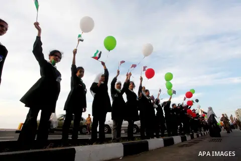Palestinians hold balloons in the colour of the national flag waits for the arrival of Emir of Qatar Sheik Hamad bin Khalifa al-Thani in Gaza City on October 23, 2012. Qatar's emir was warmly welcomed on a landmark tour...