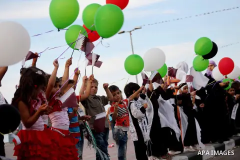 Palestinians hold balloons in the colour of the national flag waits for the arrival of Emir of Qatar Sheik Hamad bin Khalifa al-Thani in Gaza City on October 23, 2012. Qatar's emir was warmly welcomed on a landmark tour...
