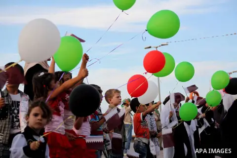 Palestinians hold balloons in the colour of the national flag waits for the arrival of Emir of Qatar Sheik Hamad bin Khalifa al-Thani in Gaza City on October 23, 2012. Qatar's emir was warmly welcomed on a landmark tour...