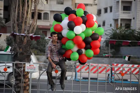 Palestinians hold balloons in the colour of the national flag waits for the arrival of Emir of Qatar Sheik Hamad bin Khalifa al-Thani in Gaza City on October 23, 2012. Qatar's emir was warmly welcomed on a landmark tour...