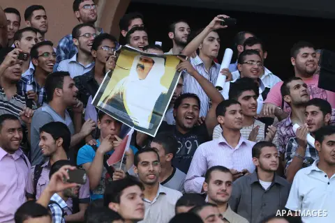 Palestinians gather during the arrival of Emir of Qatar Sheik Hamad bin Khalifa al-Thani at the Islamic University in Gaza city on October 23, 2012. The Emir of Qatar entered the Gaza Strip on Tuesday for a visit that br...