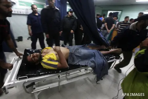 Palestinian health workers wheel the body of Palestinian man at Kamal Edwan hospital in Gaza, following an Israeli airstrike in northern town of Bite Lahia, in the Gaza Strip, on October 23, 2012. The air strike killed o...