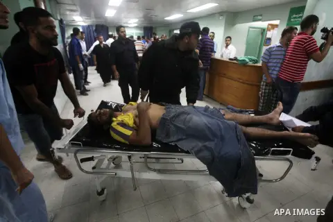 Palestinian health workers wheel the body of Palestinian man at Kamal Edwan hospital in Gaza, following an Israeli airstrike in northern town of Bite Lahia, in the Gaza Strip, on October 23, 2012. The air strike killed o...