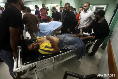 Palestinian health workers wheel the body of Palestinian man at Kamal Edwan hospital in Gaza, following an Israeli airstrike in northern town of Bite Lahia, in the Gaza Strip, on October 23, 2012. The air strike killed o...