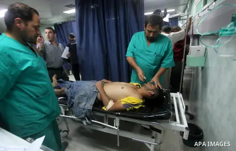 Palestinian health workers wheel the body of Palestinian man at Kamal Edwan hospital in Gaza, following an Israeli airstrike in northern town of Bite Lahia, in the Gaza Strip, on October 23, 2012. The air strike killed o...