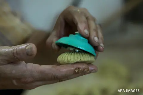 A Palestinian worker makes traditional date-filled cookies in preparation for the of Eid al-Adha, in the West Bank city of Nablus, on October 23, 2012. Muslims around the world prepare to celebrate Eid Al-Adha, which acc...