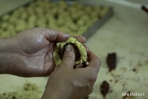 A Palestinian worker makes traditional date-filled cookies in preparation for the of Eid al-Adha, in the West Bank city of Nablus, on October 23, 2012. Muslims around the world prepare to celebrate Eid Al-Adha, which acc...